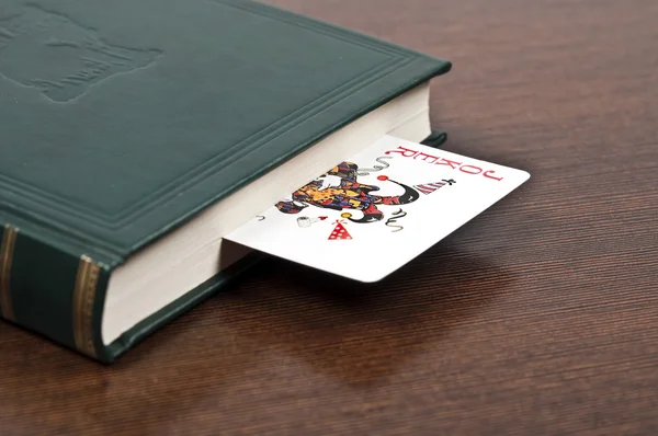 Book and joker card — Stock Photo, Image