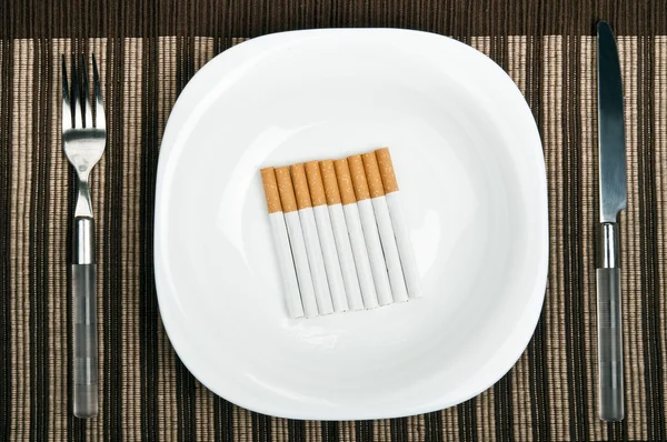 Cigaretter på mat tallrik — Stockfoto