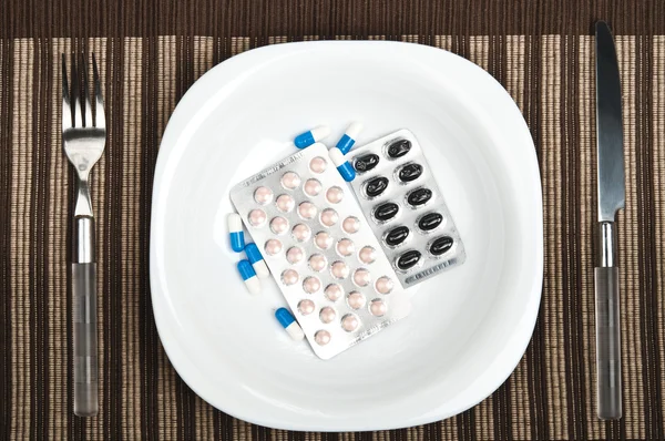 Pills on food plate — Stock Photo, Image