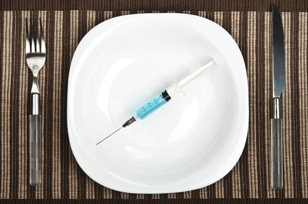 Syringe on food plate — Stock Photo, Image
