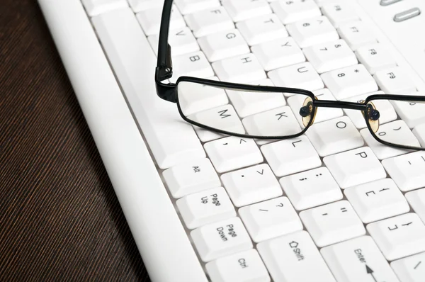 Eye glasses on keyboard — Stock Photo, Image