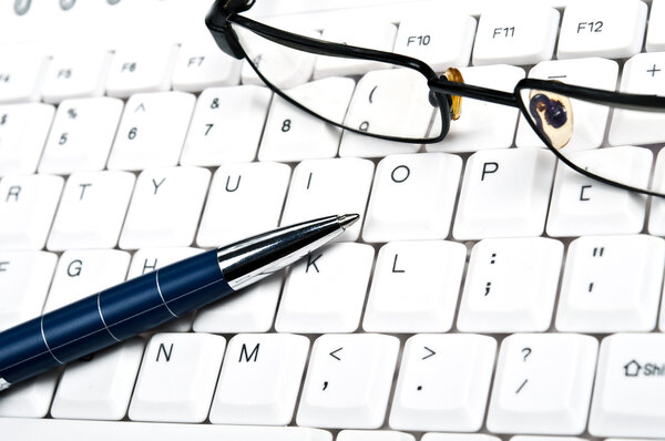 Eye glasses on an white keyboard