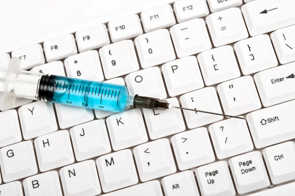 Syringe on keyboard — Stock Photo, Image