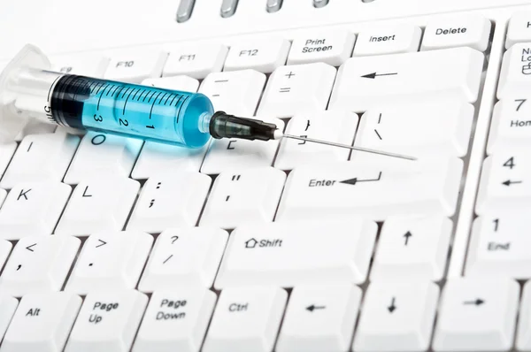 Syringe on keyboard — Stock Photo, Image