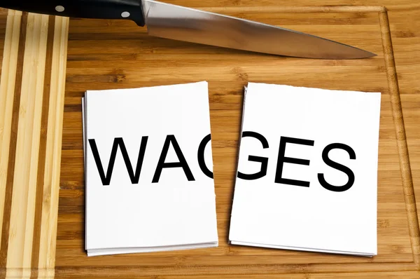 Knife cut paper with wages — Stock Photo, Image
