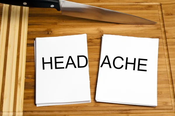 Messer schneiden Papier mit Kopfschmerzen — Stockfoto