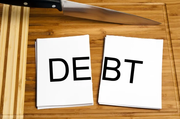 Cuchillo papel cortado con deuda — Foto de Stock