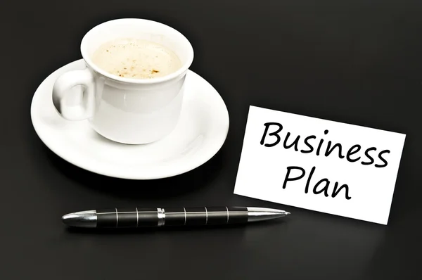 Plan de negocios anotado en el escritorio con café — Foto de Stock