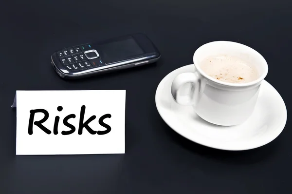Risikobotschaft auf dem Schreibtisch mit Kaffee — Stockfoto