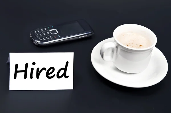 Hired noted on desk with coffee — Stock Photo, Image