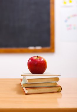 Red apple on books in class room clipart