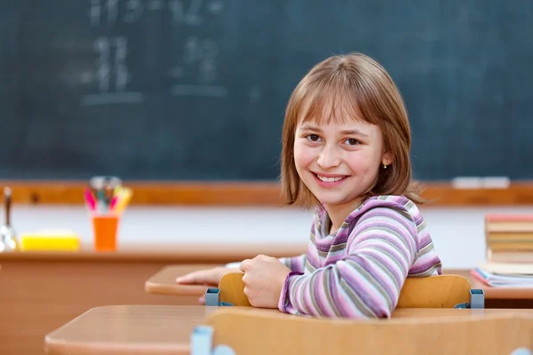 Δημοτικό σχολείο κορίτσι γυρίζει πίσω και χαμογελαστός — Φωτογραφία Αρχείου