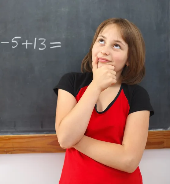 Elementaire schoolmeisje denken over oplossing — Stockfoto