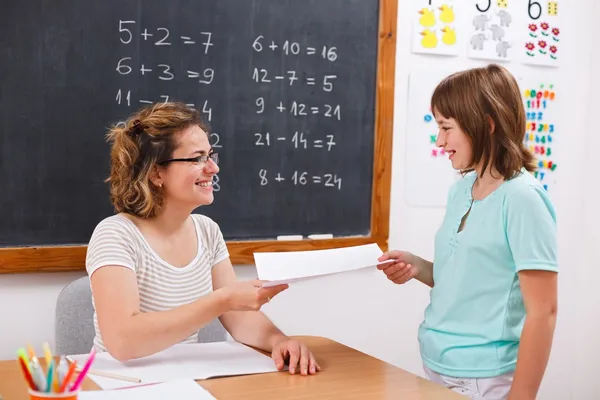 Schoolmeisje geven of ontvangen van math test papier — Stockfoto