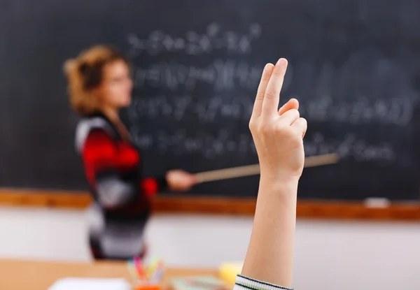 Поднятая рука в классе математики — стоковое фото