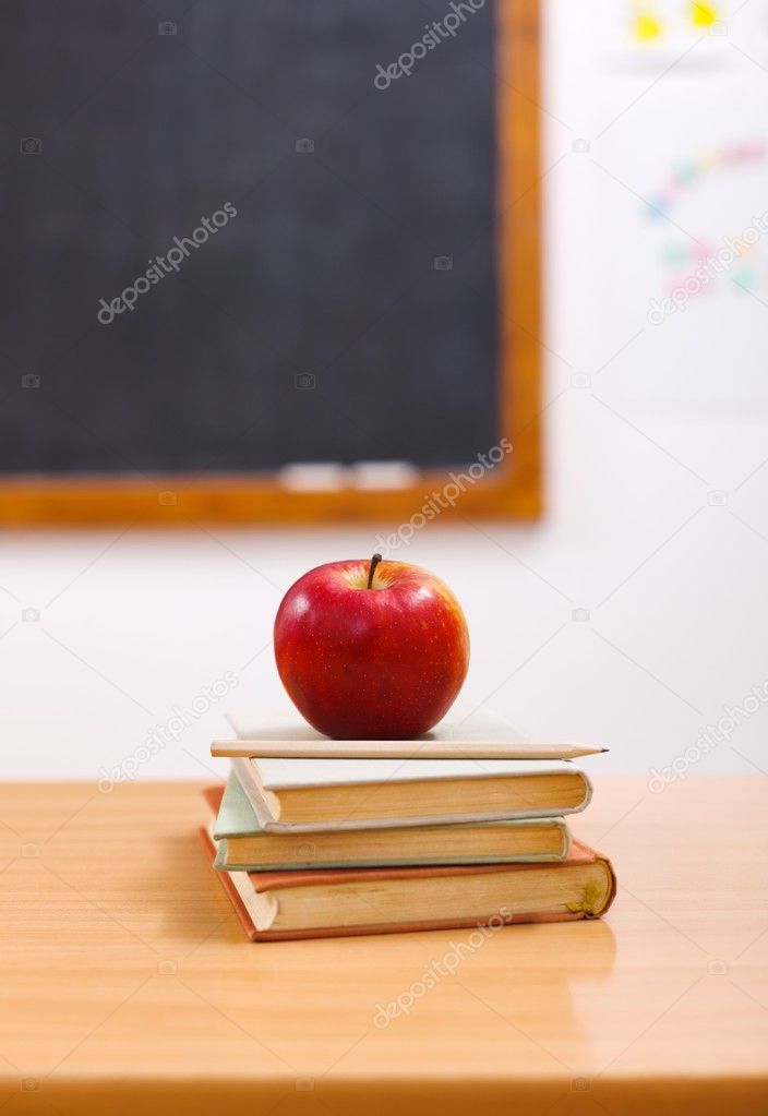 Red apple on books in class room