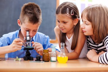 Boy looking into microscope clipart