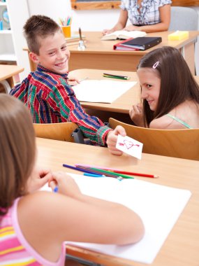 Elementary school boy giving love letter to his colleague clipart