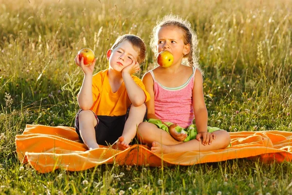 Petite fille et garçon manger de la pomme — Photo