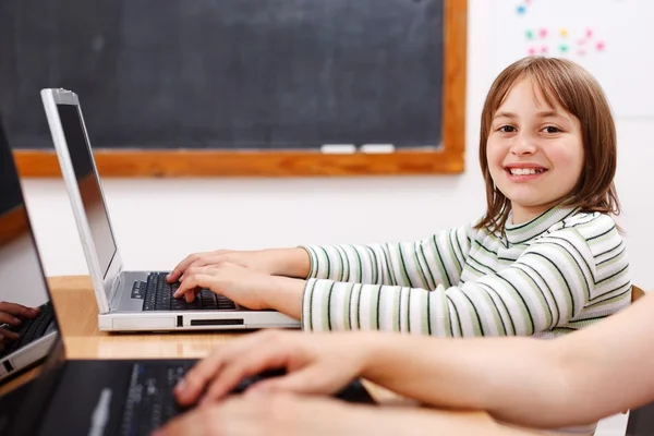 Веселая школьница с ноутбуком — стоковое фото