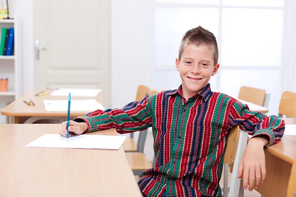 Уверенный мальчик, сидящий один в классе — стоковое фото