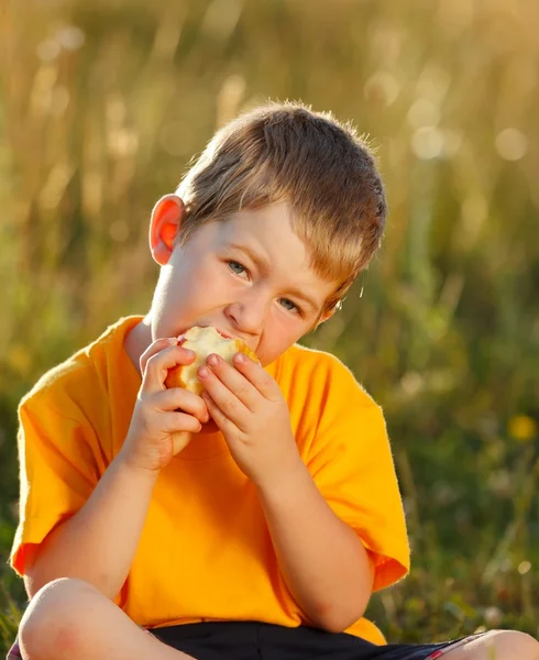 Junge isst Apfel — Stockfoto