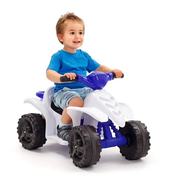 Маленький мальчик на игрушечной машине — стоковое фото
