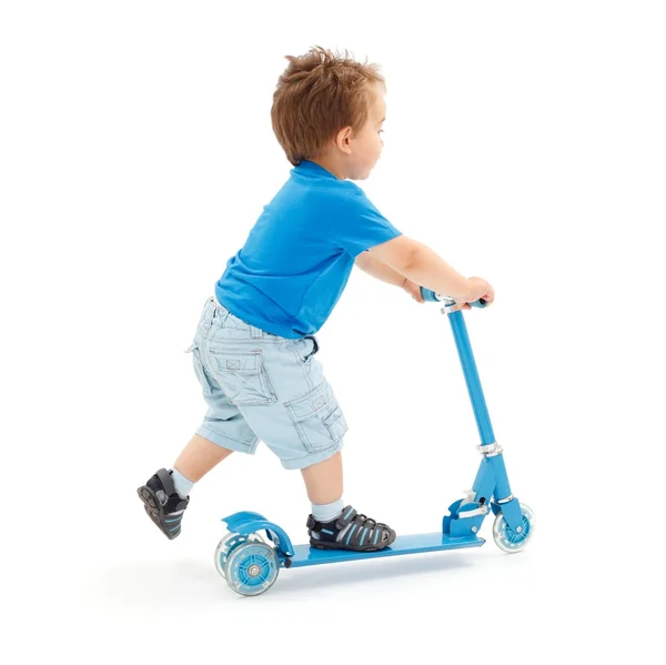Маленький мальчик идет со скутером — стоковое фото