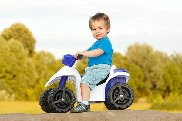 Маленький хлопчик сидить на іграшковому квадроциклі — стокове фото