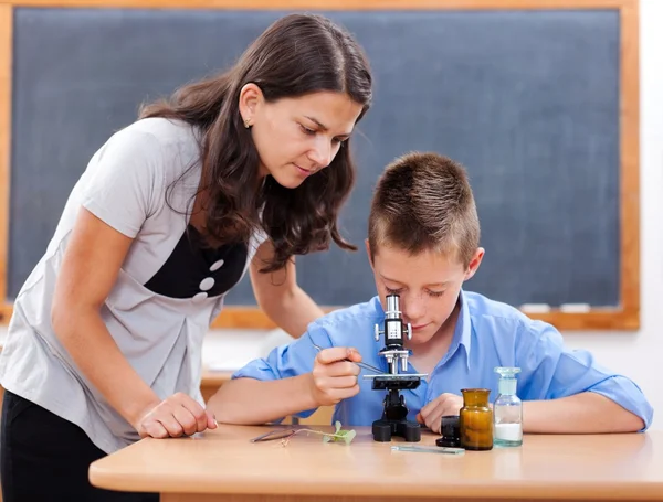 男孩看着显微镜 — 图库照片