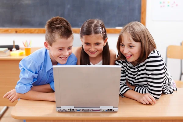 Crianças felizes olhando para laptop Imagens Royalty-Free