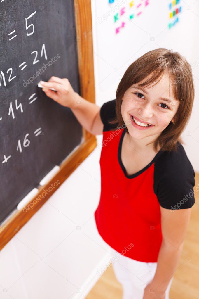 Schoolgirl looking up in front of chalkboard