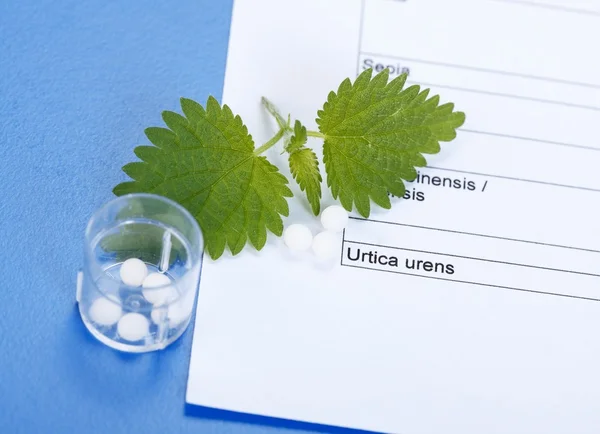 Urica Urens e pílulas em folha homeopática — Fotografia de Stock