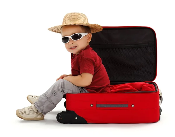 Confident little boy wearing straw hat, sitting in suitcase — Stock Photo, Image