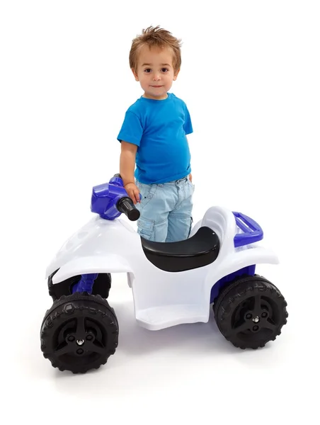 Mały chłopiec stojący w pobliżu zabawka off road quad — Zdjęcie stockowe