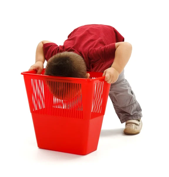 Kleine jongen op zoek diep in de vuilnisbak — Stockfoto