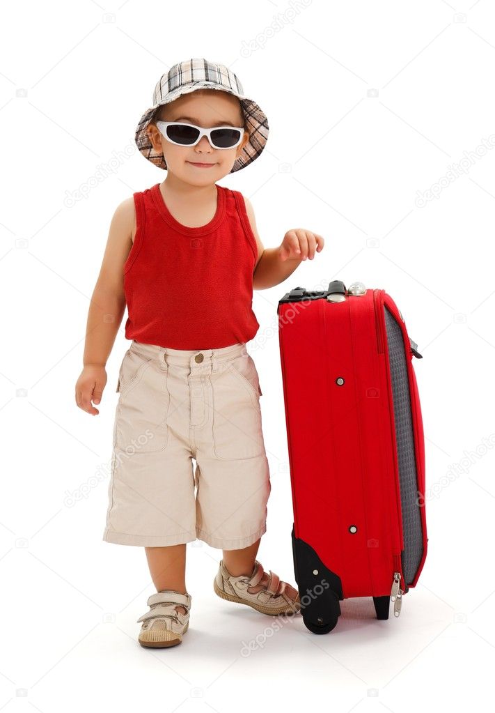 Little boy standing near luggage, ready for journey