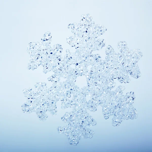 Closeup of falling snowflake on clear blue background — Stock Photo, Image