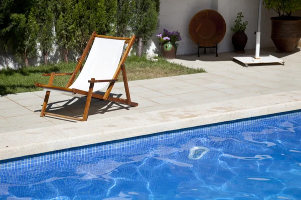 Deckchair in a swimming pool — Stock Photo, Image