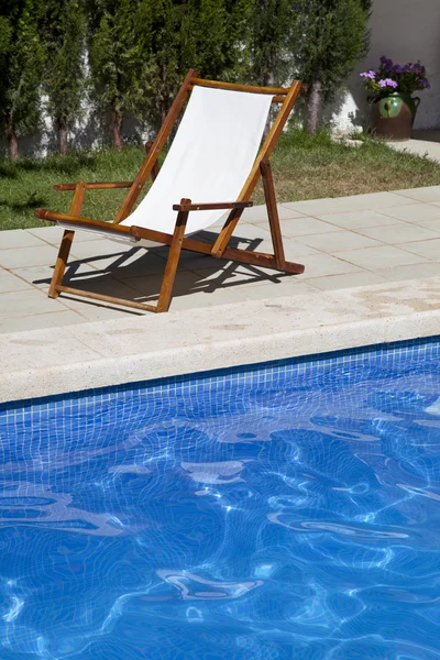 Deckchair in a swimming pool — Stock Photo, Image