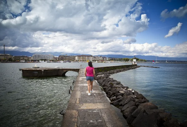 Молода жінка, ходьба в доці Jet d'Eau в Женеві — стокове фото