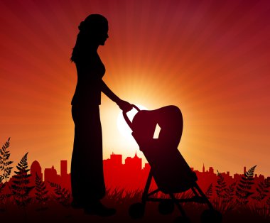 Mother and baby carriage on sunset background