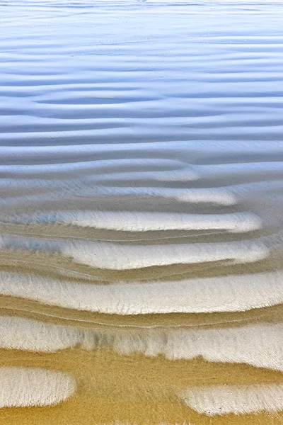Nasse Sandstruktur an der Küste des Ozeans — Stockfoto