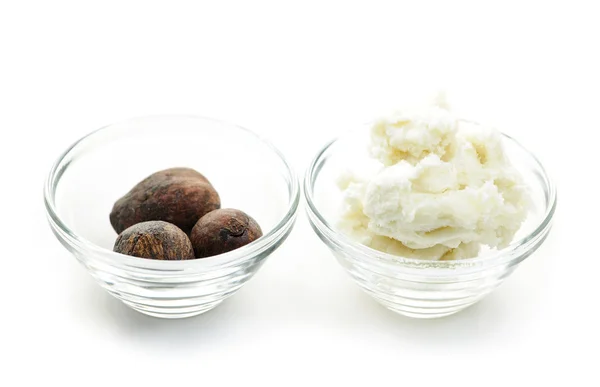 Shea butter and nuts in bowls — Stock Photo, Image