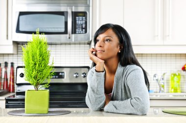 Thoughtful woman in kitchen clipart