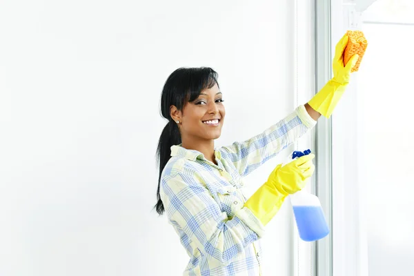 Mulher sorridente limpando janelas — Fotografia de Stock