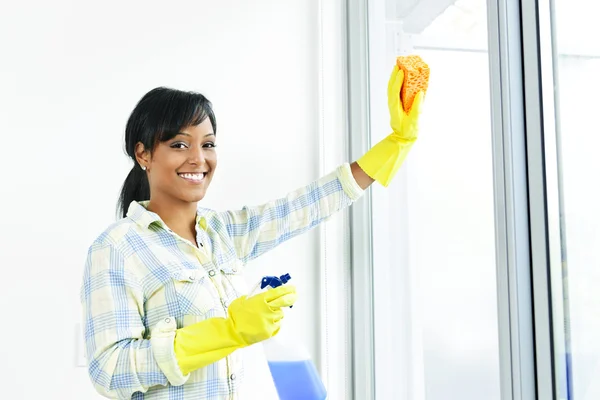 Lachende vrouw schoonmaak windows — Stockfoto