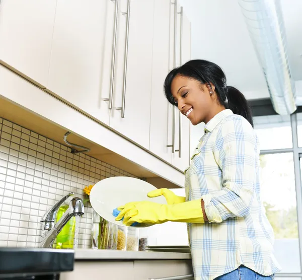Jovem mulher lavando pratos — Fotografia de Stock