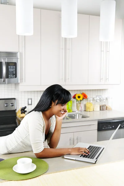 Kobieta za pomocą komputera w kuchni — Zdjęcie stockowe
