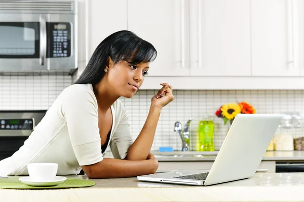 Kobieta za pomocą komputera w kuchni — Zdjęcie stockowe
